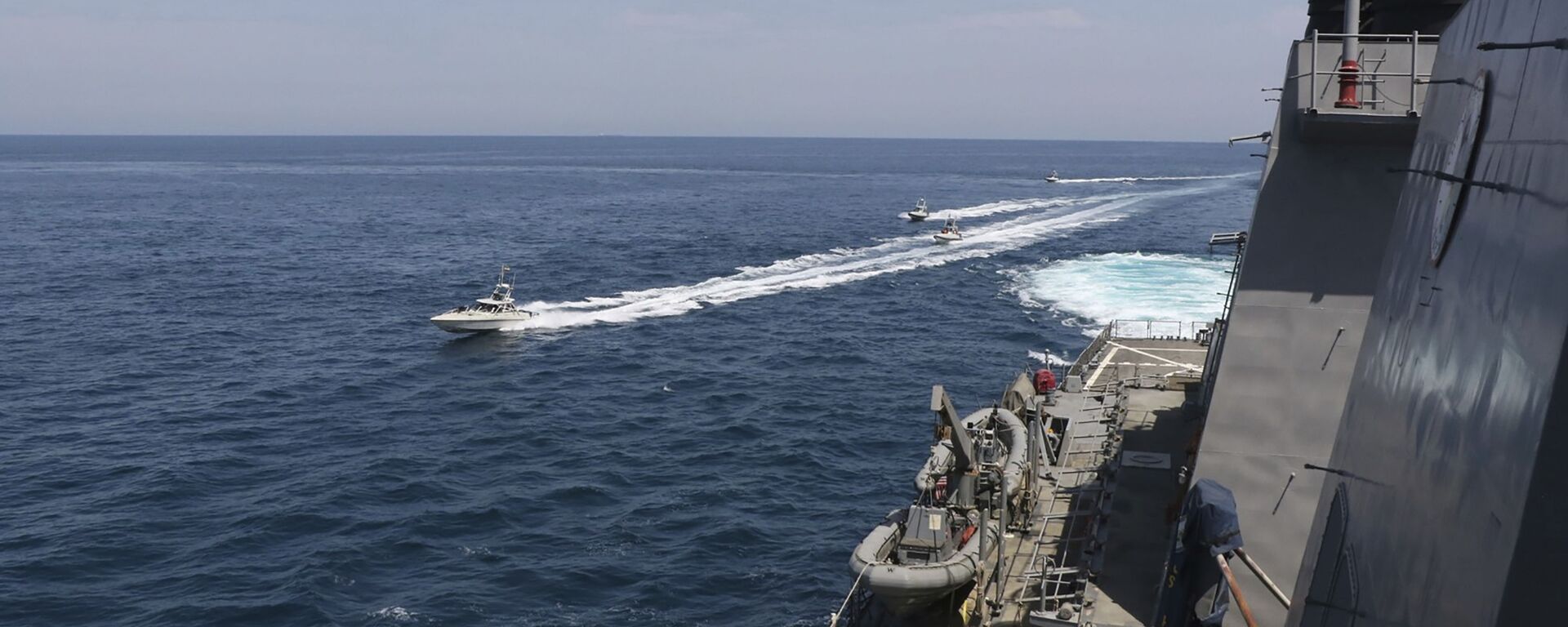 Lanchas da Marinha do Corpo de Guardiões da Revolução Islâmica do Irã navegam perto de navios militares dos EUA no golfo Pérsico perto de Kuwait, 15 de abril de 2020 - Sputnik Brasil, 1920, 11.01.2024