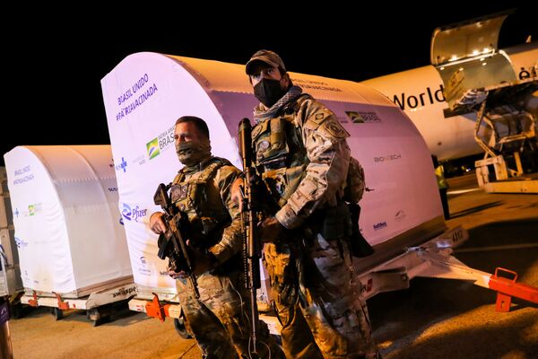 Membros das forças de segurança vigiam perto dos contêineres com doses da vacina da Pfizer/BioNTech no Aeroporto Internacional de Viracopos, Campinas, São Paulo, Brasil, 29 de abril de 2021 - Sputnik Brasil