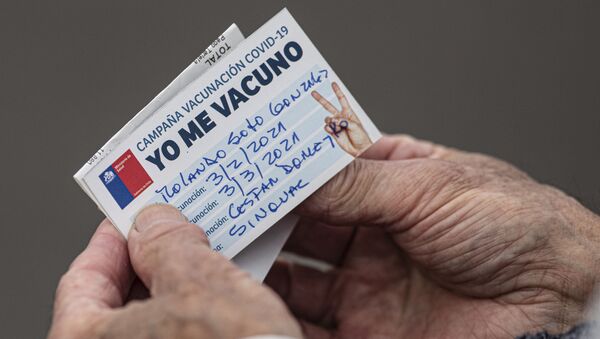 Um senhor chileno olha para seu cartão de vacinação após receber uma injeção da CoronaVac, em Santiago, no dia 3 de fevereiro de 2021 - Sputnik Brasil