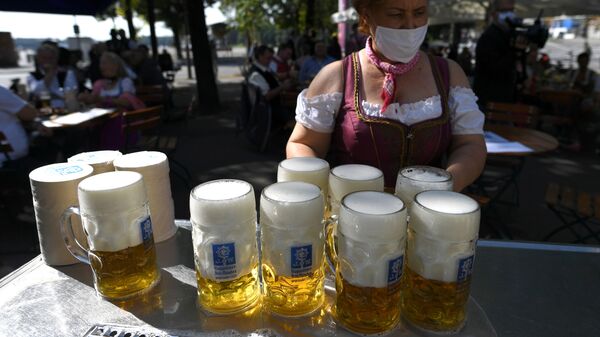 Em Munique, na Alemanha, uma garçonete carrega canecas de cerveja na região onde a Oktoberfest seria realizada se não tivesse sido cancelada devido à pandemia, 3 de maio de 2021. - Sputnik Brasil