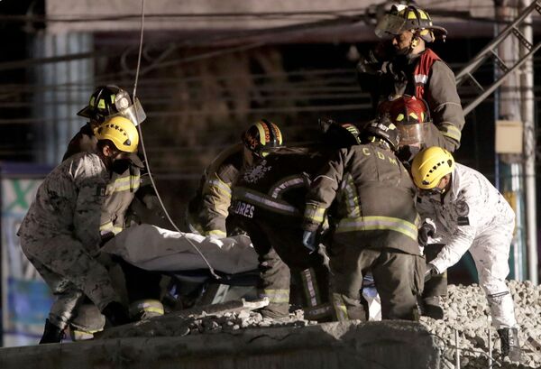 Socorristas carregam um morto no local de desabamento do viaduto do metrô na estação Olivos na Cidade do México, 3 de maio de 2021 - Sputnik Brasil