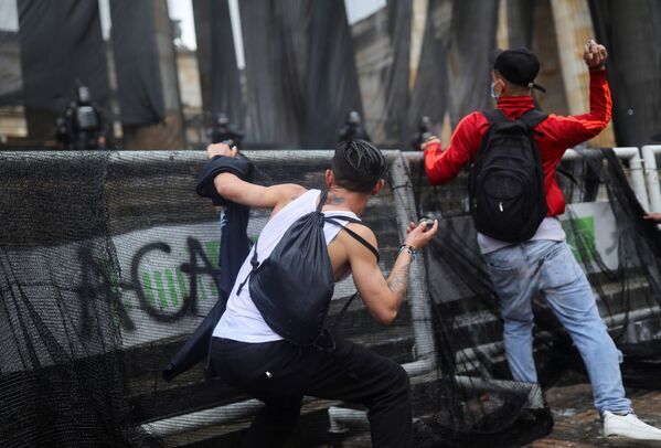 Manifestantes jogam pedras durante os protestos em Bogotá, Colômbia, 5 de maio de 2021 - Sputnik Brasil