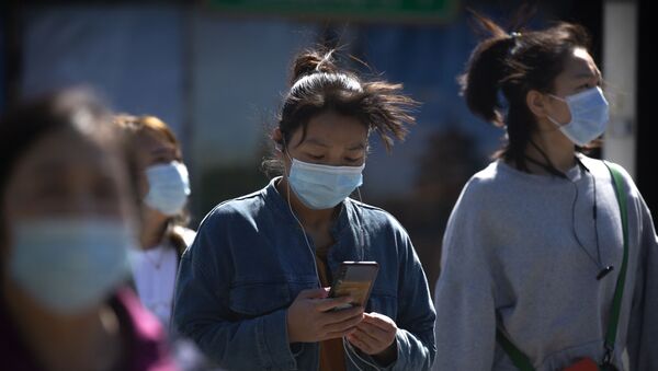 Pedestres usam máscara protetora nas ruas da capital chinesa, Pequim, 7 de março de 2021  - Sputnik Brasil