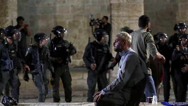Um palestino ora enquanto a polícia israelense se reúne durante confrontos no complexo que abriga a mesquita de Al-Aqsa, 7 de maio de 2021 - Sputnik Brasil