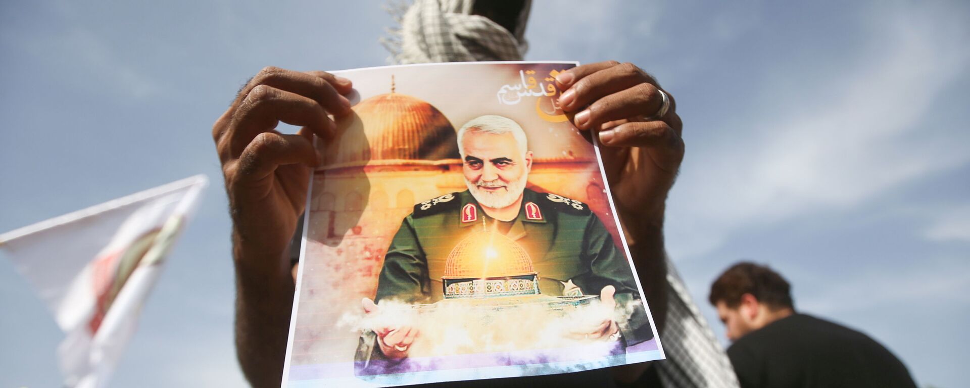 Membro das Unidades de Mobilização Popular do Iraque (PMU, na sigla em inglês) mostra foto de Qassem Soleimani, general iraniano assassinado em 3 de janeiro de 2020, em Basra, Iraque, 7 de maio de 2021 - Sputnik Brasil, 1920, 09.01.2022
