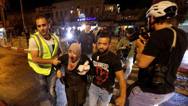 Em Jerusalém, uma mulher palestina ferida é levada embora durante confrontos com a polícia de Israel em meio ao mês sagrado do Ramadã, em 8 de maio de 2021 - Sputnik Brasil