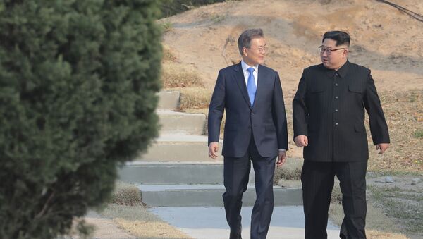 O líder norte-coreano Kim Jong-un (à direita) e o presidente sul-coreano, Moon Jae-in, passeiam juntos em Panmunjom, na zona desmilitarizada na Coreia do Sul, em um momento que as duas coreias estavam tecendo um diálogo mais próximo, 27 de abril de 2018 - Sputnik Brasil