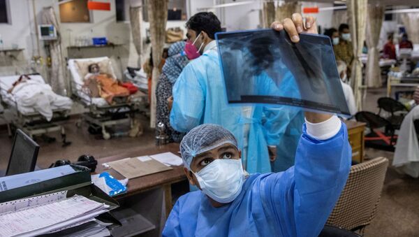 Médico responsável pelos pacientes com COVID-19 observa raio-X durante turno de 27 horas em hospital em Nova Deli, Índia, 1º de maio de 2021 - Sputnik Brasil
