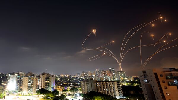Raios de luz são vistos quando o sistema antimíssil Cúpula de Ferro de Israel intercepta foguetes lançados da Faixa de Gaza, vistos de Ashkelon, Israel, em 10 de maio de 2021 - Sputnik Brasil