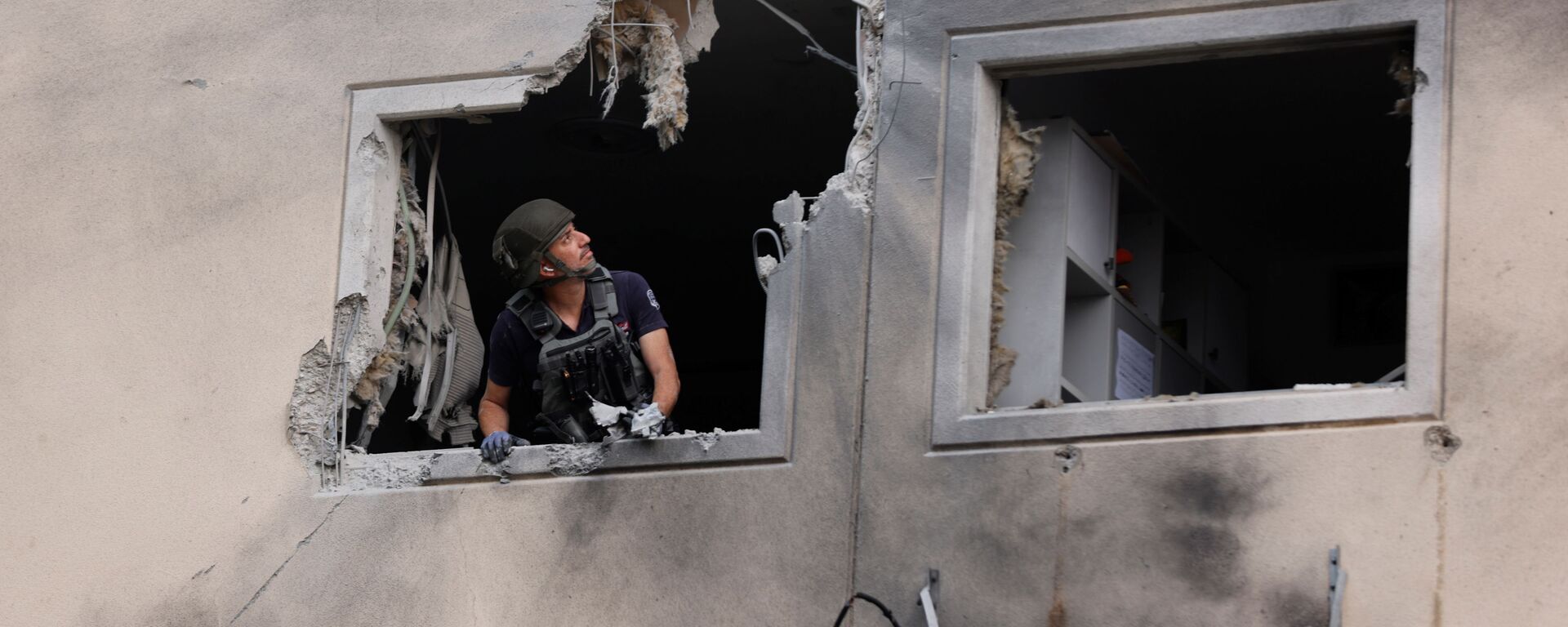 Especialista do esquadrão antibombas da polícia de Israel na janela de um prédio residencial danificado após ser atingido por um foguete lançado da Faixa de Gaza, 11 de maio de 2021. - Sputnik Brasil, 1920, 20.04.2022