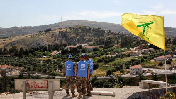 Membros da força de paz da ONU perto de uma bandeira do Hezbollah monitorando a situação na fronteira entre Líbano e Israel - Sputnik Brasil