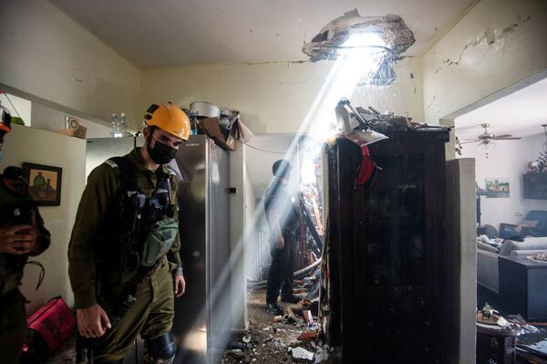 Soldados trabalham em um prédio danificado por um foguete lançado de Gaza, contra Ashdod, no sul de Israel - Sputnik Brasil