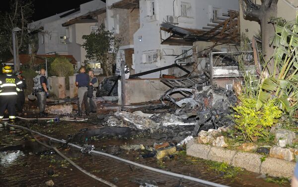 Agentes dos serviços de emergência de Israel inspecionam os danos na cidade israelense de Rishon Lezion, após foguetes lançados de Gaza atingirem a região - Sputnik Brasil
