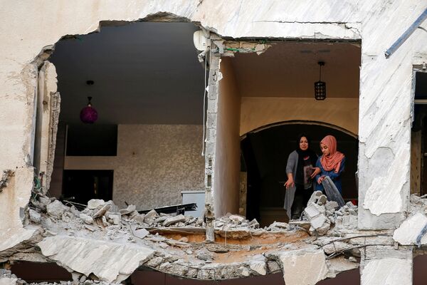 Palestinas observam suas casas danificadas durante bombardeio israelense em Gaza - Sputnik Brasil