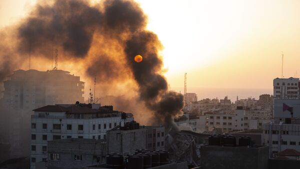 Fumaça é vista saindo de um prédio destruído após ter sido bombardeado por Israel na cidade de Gaza, 12 de maio de 2021 - Sputnik Brasil