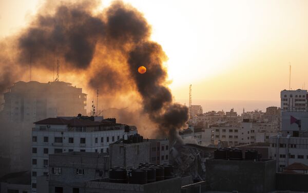 Fumaça é vista saindo de um prédio destruído após ter sido bombardeado por Israel na cidade de Gaza, 12 de maio de 2021 - Sputnik Brasil