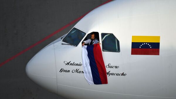 Em Moscou, um piloto da companhia aérea venezuelana Conviasa mostra uma bandeira da Rússia após a chegada ao aeroporto de Vnukovo no primeiro voo da rota direta entre a capital russa e Caracas, em 15 de maio de 2021 - Sputnik Brasil