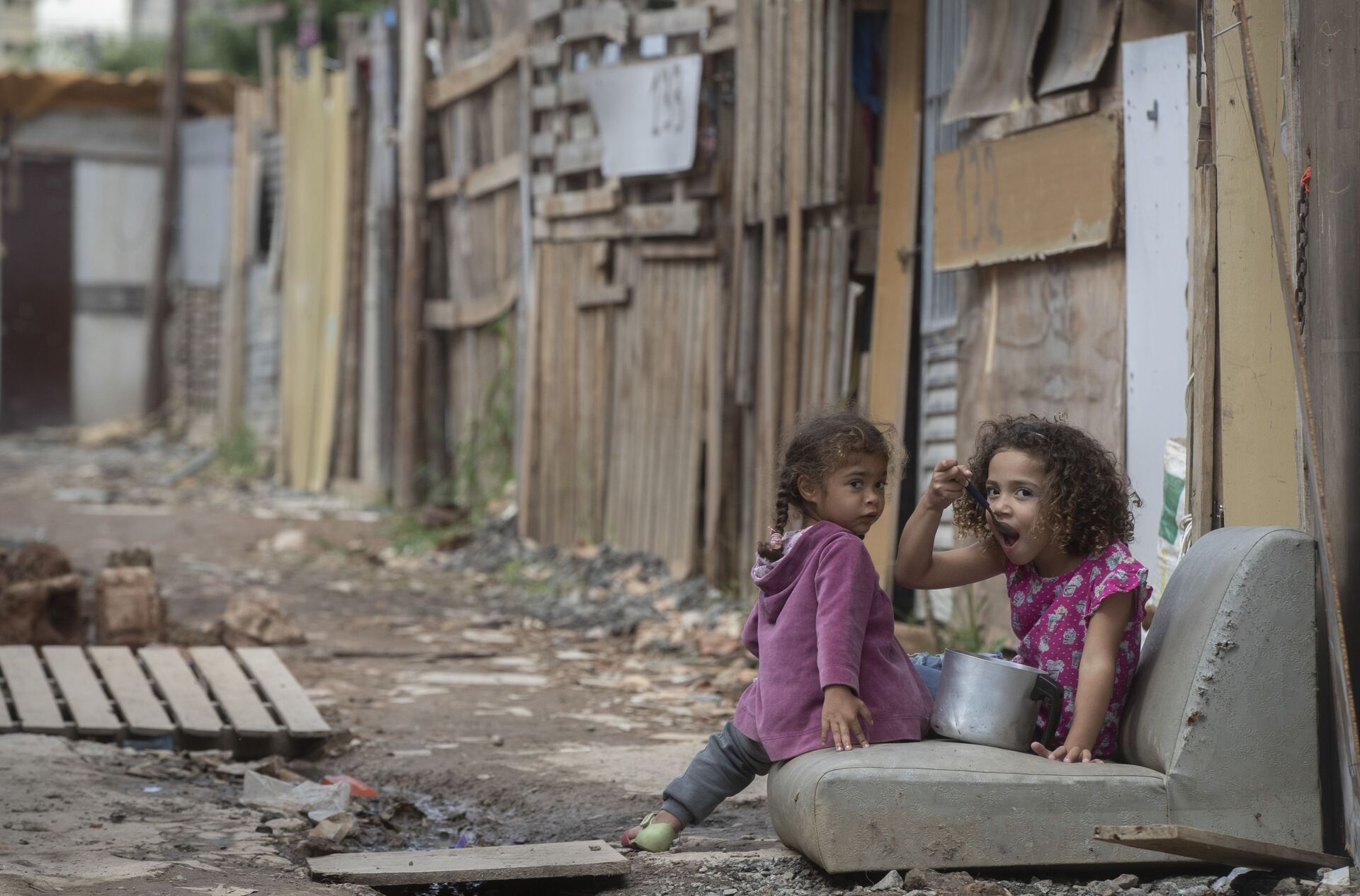 Criança come olhando para a câmera na favela da Penha, durante a pandemia de coronavírus em São Paulo, 16 maio de 2021 - Sputnik Brasil, 1920, 18.01.2022