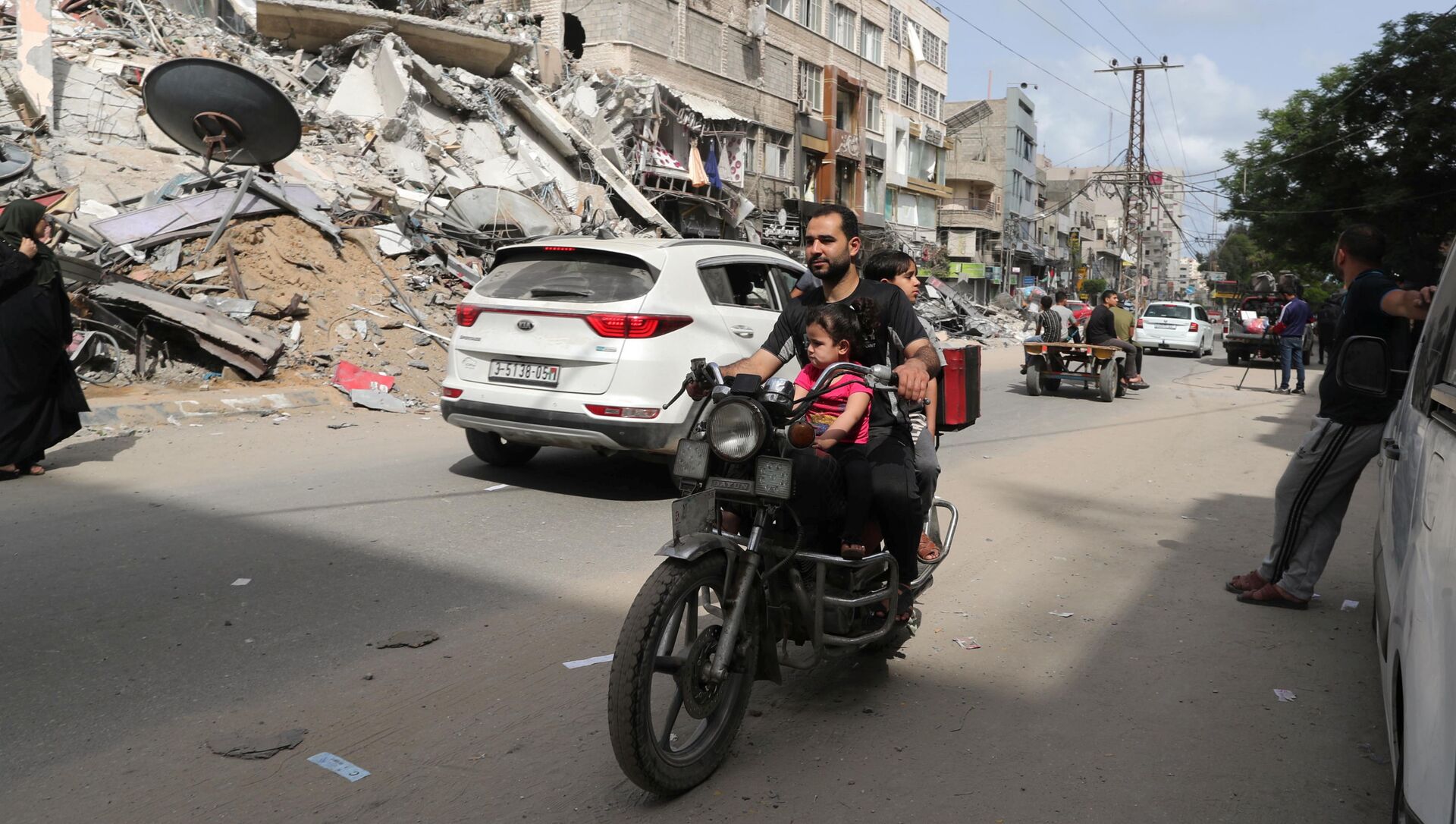 Palestinos passam de moto por área atingida por ataque aéreo israelense, Faixa de Gaza, 21 de maio de 2021 - Sputnik Brasil, 1920, 21.05.2021