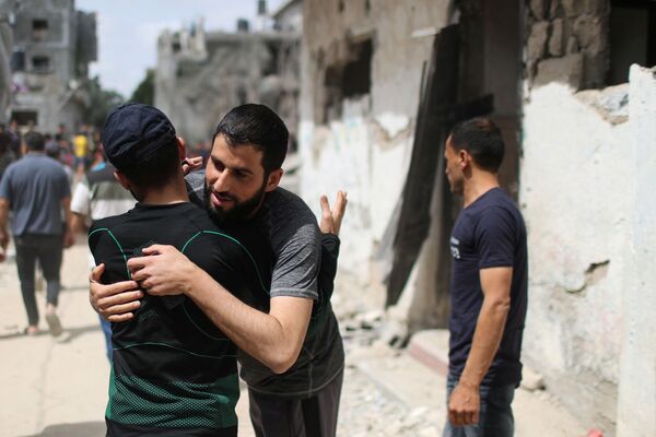 Palestinos se abraçam ao voltarem para suas casas destruídas após o cessar-fogo entre Israel e o Hamas, no noroeste de Faixa de Gaza, 21 de maio de 2021 - Sputnik Brasil