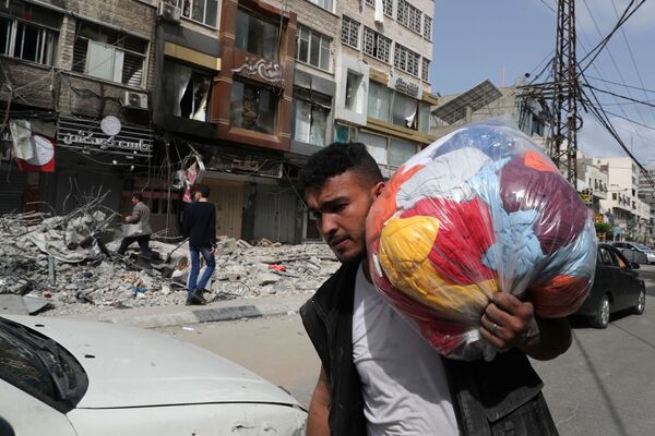 Palestino passando ao lado das ruínas geradas por ataque aéreo israelense durante o conflito entre o Hamas e Israel, Faixa de Gaza, 21 de maio de 2021 - Sputnik Brasil