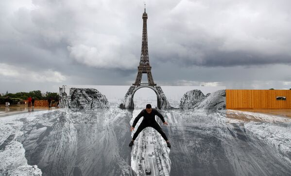 Homem posa na frente de obra gigante do artista francês JR na Praça Trocadéro, junto à Torre Eiffel, Paris, 19 de maio de 2021 - Sputnik Brasil