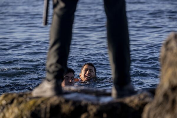 Agente da Guarda Civil da Espanha observa migrantes na costa do enclave espanhol de Ceuta, no norte de África, perto da fronteira entre Marrocos e Espanha, 19 de maio de 2021 - Sputnik Brasil