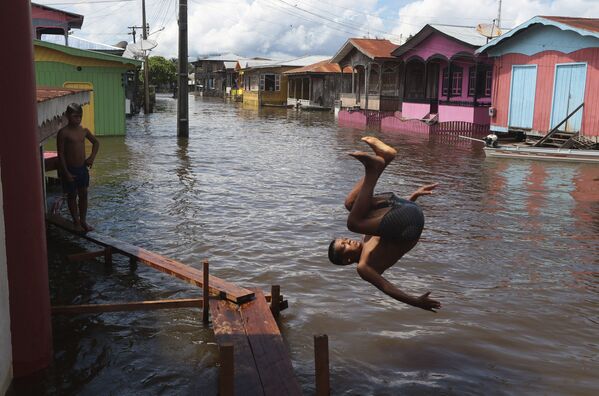 Menino salta para a água em rua inundada no estado do Amazonas, Brasil - Sputnik Brasil