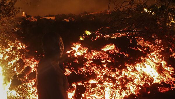 Uma pessoa fica em frente à lava da erupção do monte Nyiragongo, em Buhene, nos arredores de Goma, no Congo, na madrugada de domingo, 23 de maio de 2021 - Sputnik Brasil
