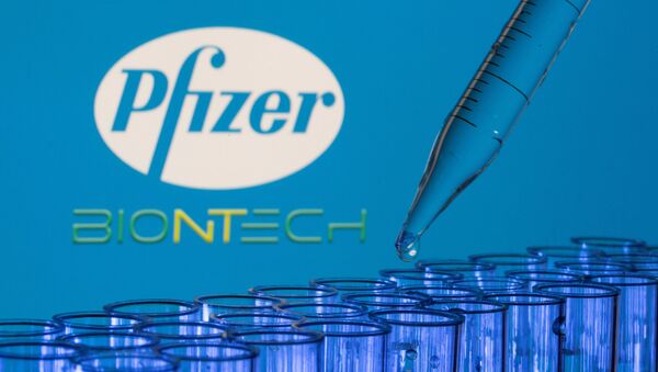 Tubos de testes são vistos na frente dos logotipos da Pfizer da BioNTech, 21 de maio de 2021 - Sputnik Brasil