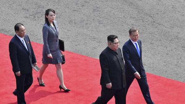 O líder norte-coreano, Kim Jong-un (de óculos), caminha com o presidente sul-coreano, Moon Jae-in, seguidos pela irmã de Kim Kim Yo-jong, para fazer uma reunião na aldeia fronteiriça de Panmunjom, na Zona Desmilitarizada da Coreia, 27 de abril de 2018. - Sputnik Brasil