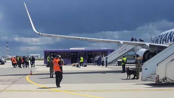 Pessoal do aeroporto e forças de segurança na pista em frente a um voo da Ryanair que foi forçado a pousar em Minsk, Belarus, 23 de maio de 2021 - Sputnik Brasil