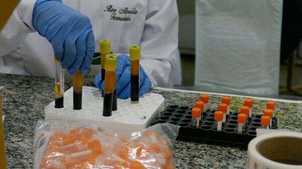 Profissional da saúde mexe em frascos com soro separado do sangue, em 20 de março de 2021 - Sputnik Brasil