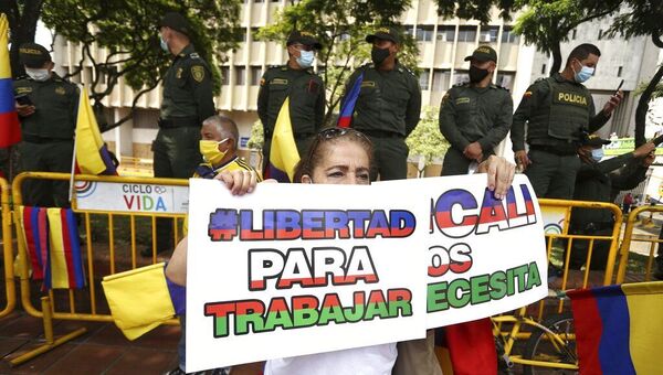 Mulher segura placa durante uma marcha silenciosa para apoiar o desbloqueio das principais vias de entrada e saída da cidade que foram bloqueadas por protestos antigovernamentais em Cali, Colômbia, terça-feira, 25 de maio de 2021 - Sputnik Brasil
