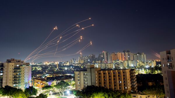 Raios de luz são vistos de Ashkelon quando o sistema antimíssil Iron Dome de Israel intercepta foguetes lançados da Faixa de Gaza em direção a Israel, em 15 de maio de 2021 - Sputnik Brasil