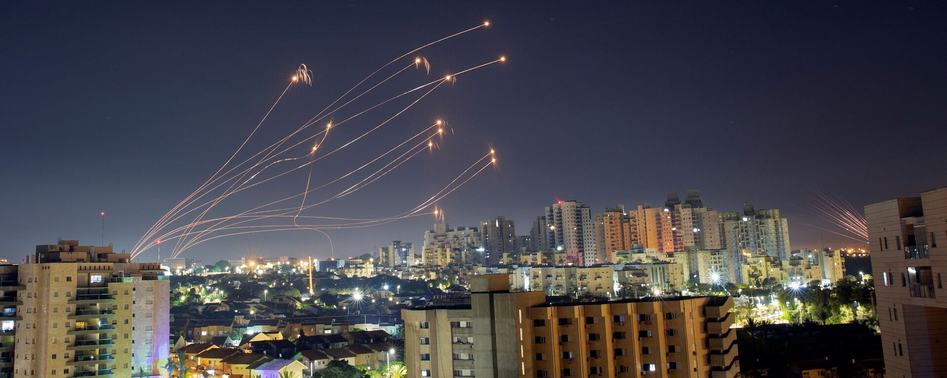 Raios de luz são vistos de Ashkelon quando o sistema antimíssil Iron Dome de Israel intercepta foguetes lançados da Faixa de Gaza em direção a Israel, em 15 de maio de 2021 - Sputnik Brasil, 1920, 02.01.2022