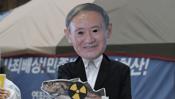 Manifestante em máscara do premiêr japonês, Yoshihide Suga, durante o protesto contra despejo de água contaminada da usina nuclear de Fukushima, 13 de abril de 2021 - Sputnik Brasil
