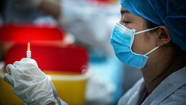 Foto tirada em 28 de abril de 2021 mostra uma profissional de saúde preparando uma dose de vacina contra o coronavírus em uma universidade em Wuhan, na província de Hubei, na China - Sputnik Brasil