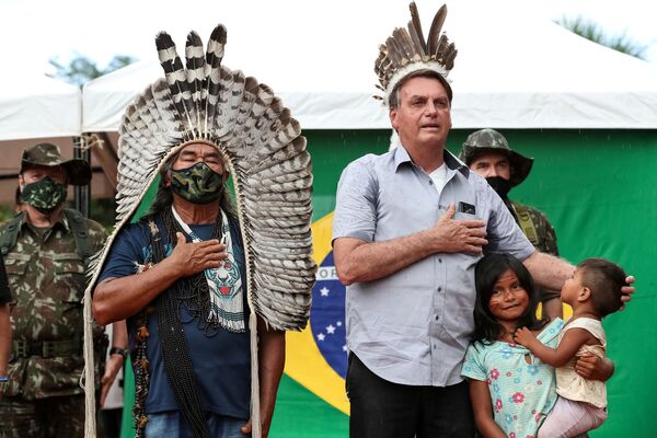 Presidente Jair Bolsonaro ouve o hino nacional junto com um indígena na reserva da tribo Yanomami, Amazonas, Brasil, 27 de maio de 2021 - Sputnik Brasil