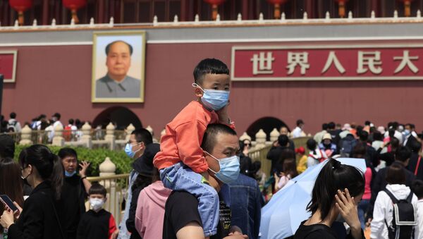 Homem carrega criança nas costas perto da Porta de Tiananmen em Pequim com retrato de Mao Tsé-tung ao fundo - Sputnik Brasil
