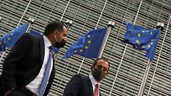 Pessoas passam por bandeiras da União Europeia içadas na sede da Comissão Europeia em Bruxelas, Bélgica, 5 de maio de 2021 - Sputnik Brasil