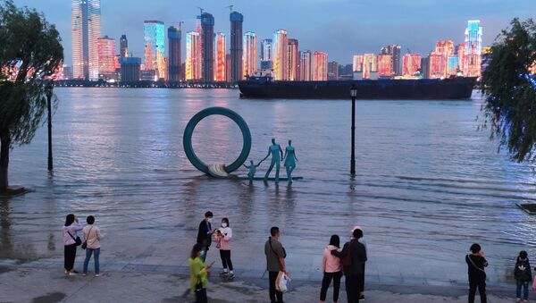 People stand next to an overflowing section of the Yangtze River at a riverside park following heavy rainfall in the region, in Wuhan, Hubei province, China May 26, 2021. - Sputnik Brasil