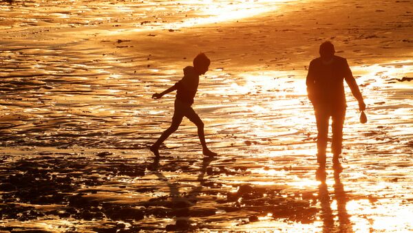 A young boy and his father enjoy sunset on the beach, amid the coronavirus disease (COVID-19) outbreak in Cayeux-sur-Mer, France, May 29, 2021. Picture taken May 29, 2021. - Sputnik Brasil