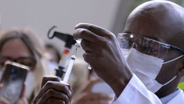Servidor da Fiocruz prepara vacina de Oxford/AstraZeneca para a primeira aplicação no Brasil. Foto de arquivo - Sputnik Brasil