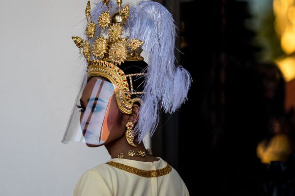 Dançarina tailandesa com um ornamento tradicional e uma proteção contra o coronavírus  - Sputnik Brasil
