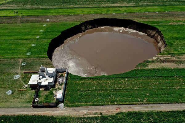 Vista aérea de um buraco gigantesco descoberto em um campo em Santa Maria Zacatepec, no México 
 - Sputnik Brasil