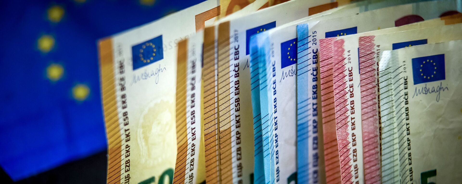 Cédulas de euro são exibidas próximo da bandeira da União Europeia - Sputnik Brasil, 1920, 04.04.2022