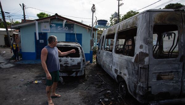 Homem olha para veículos queimados após onda de ataques violentos em Manaus, estado do Amazonas, 7 de junho de 2021 - Sputnik Brasil