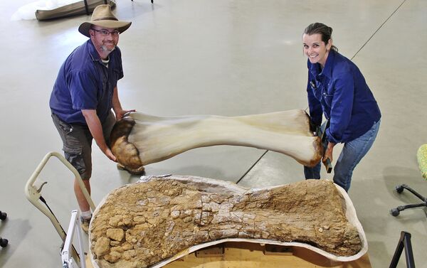 Dr. Scott Hocknull e Robyn Mackenzie posam com uma reconstrução 3D e o úmero do dinossauro encontrado em Queenslad, Austrália - Sputnik Brasil