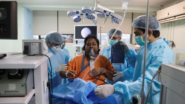 O dr. Brajpal Singh Tyagi (L) está ao lado de Usha Arya, 56, que sofre de mucormicose, também conhecida como fungo negro, após realizar uma cirurgia endoscópica nos seios da face no hospital Harsh ENT em Ghaziabad, nos arredores de Nova Deli, Índia 31 de maio, 2021 - Sputnik Brasil